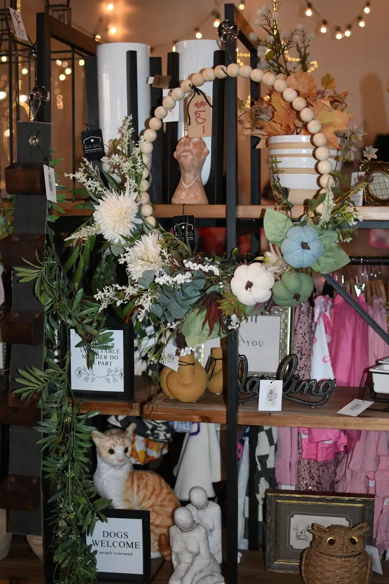 Shelves of home decor framed by a floral hoop wreath