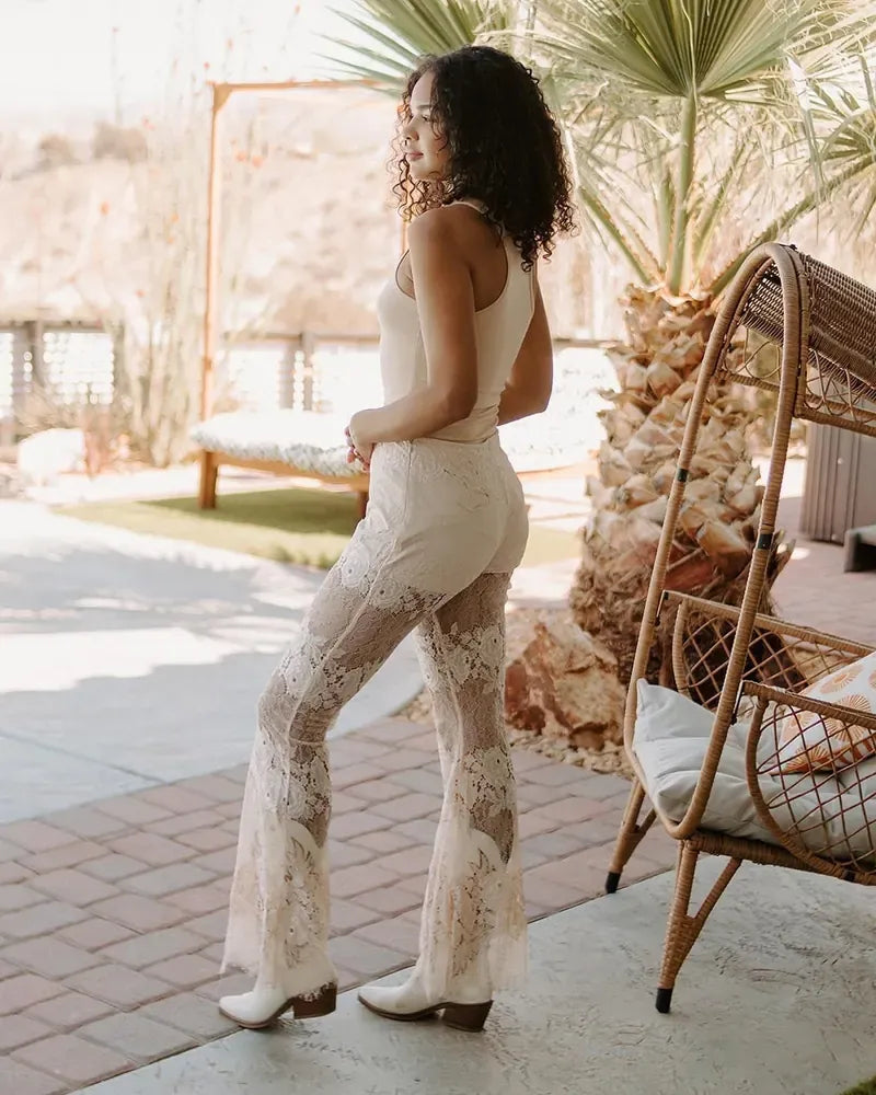 Model in a cream bodysuit, lace flares and white boots